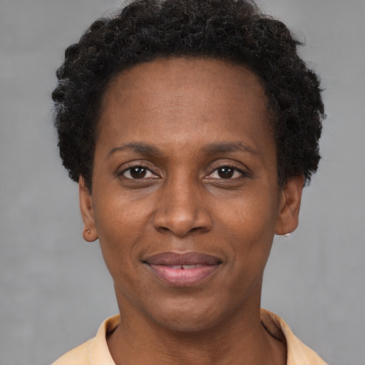 Joyful black young-adult female with short  brown hair and brown eyes