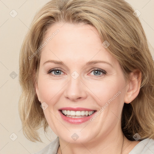 Joyful white adult female with medium  brown hair and blue eyes