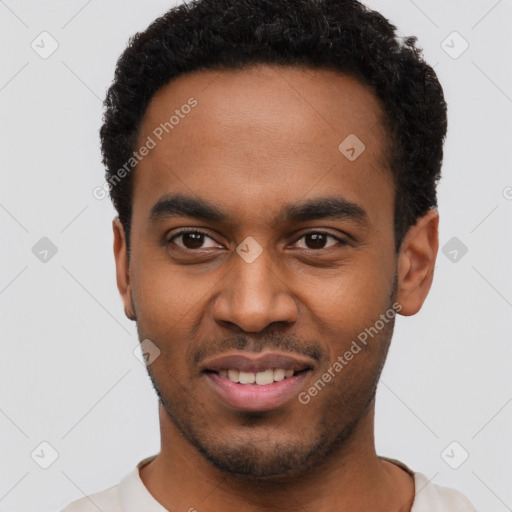 Joyful black young-adult male with short  black hair and brown eyes