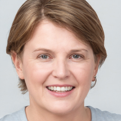 Joyful white adult female with medium  brown hair and grey eyes