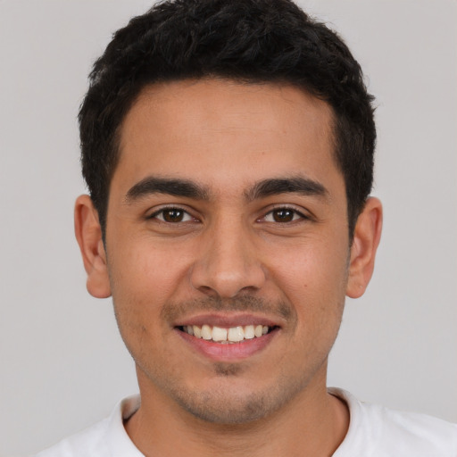 Joyful white young-adult male with short  black hair and brown eyes