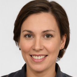 Joyful white adult female with medium  brown hair and grey eyes