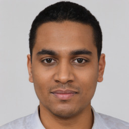 Joyful latino young-adult male with short  black hair and brown eyes