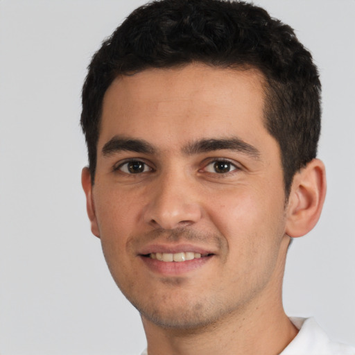 Joyful white young-adult male with short  black hair and brown eyes