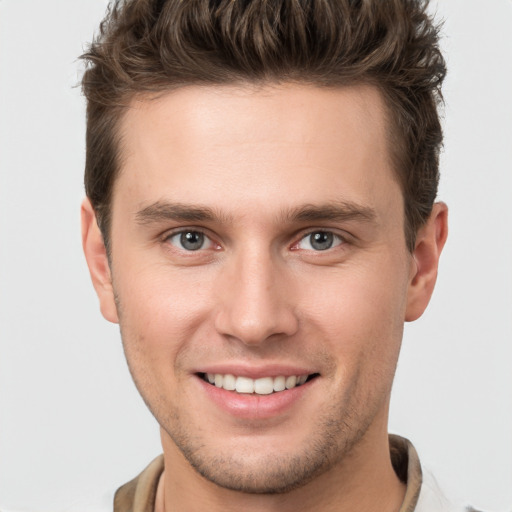 Joyful white young-adult male with short  brown hair and grey eyes