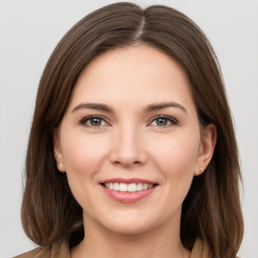 Joyful white young-adult female with long  brown hair and brown eyes