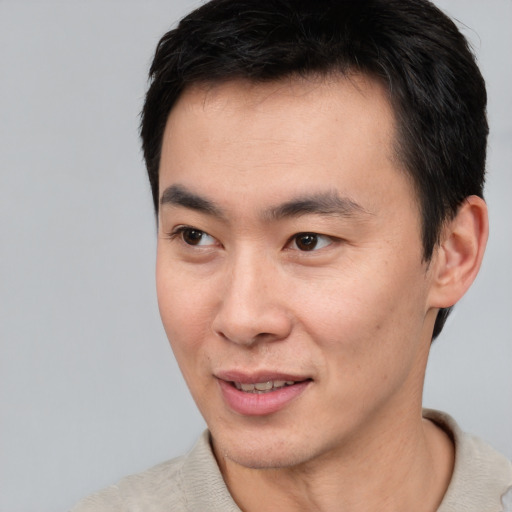 Joyful asian young-adult male with short  black hair and brown eyes