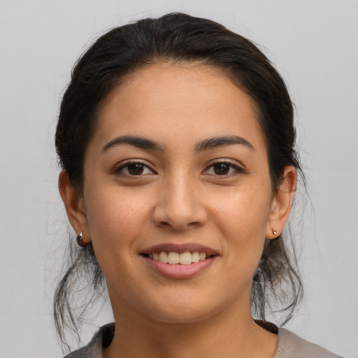 Joyful latino young-adult female with medium  brown hair and brown eyes