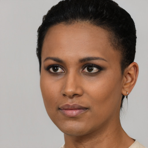 Joyful black young-adult female with short  black hair and brown eyes