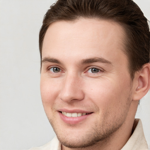 Joyful white young-adult male with short  brown hair and brown eyes