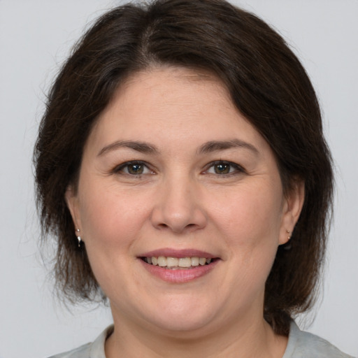 Joyful white adult female with medium  brown hair and brown eyes