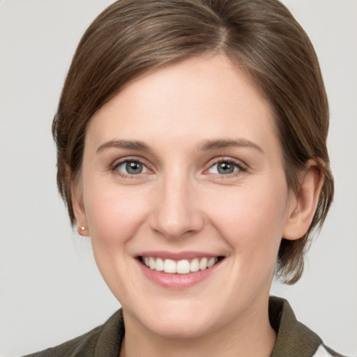 Joyful white young-adult female with medium  brown hair and grey eyes