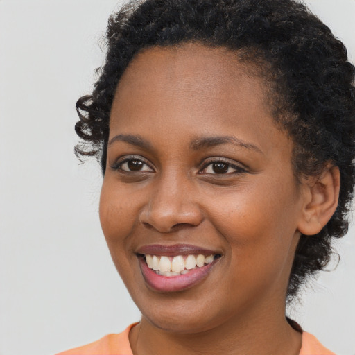 Joyful black young-adult female with short  brown hair and brown eyes