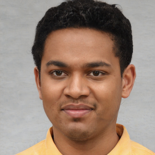 Joyful black young-adult male with short  brown hair and brown eyes