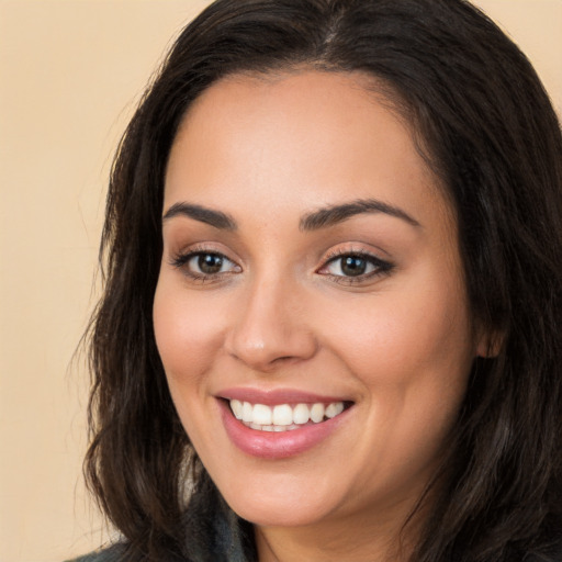 Joyful white young-adult female with long  brown hair and brown eyes