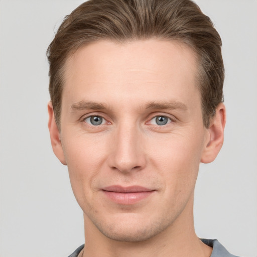 Joyful white young-adult male with short  brown hair and grey eyes