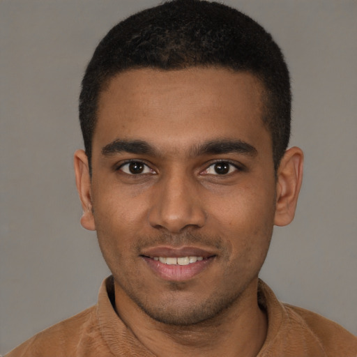Joyful black young-adult male with short  black hair and brown eyes