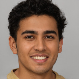 Joyful latino young-adult male with short  brown hair and brown eyes