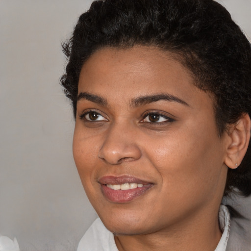 Joyful black young-adult female with short  brown hair and brown eyes