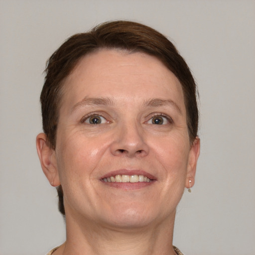 Joyful white adult female with short  brown hair and grey eyes