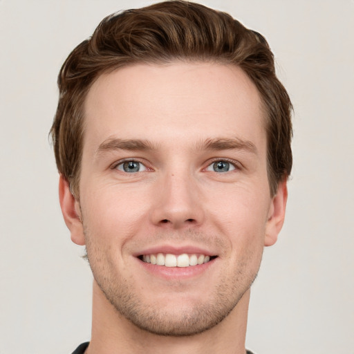 Joyful white young-adult male with short  brown hair and grey eyes