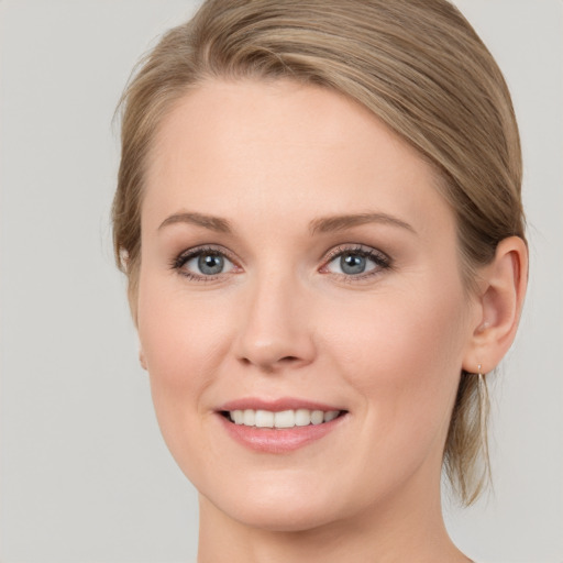 Joyful white young-adult female with medium  brown hair and blue eyes