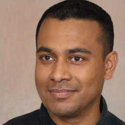 Joyful latino young-adult male with short  black hair and brown eyes