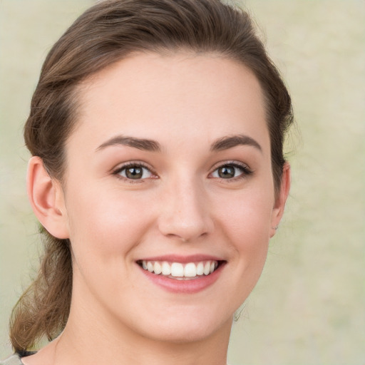 Joyful white young-adult female with medium  brown hair and green eyes