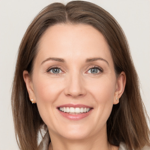 Joyful white adult female with long  brown hair and grey eyes