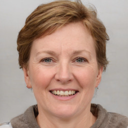 Joyful white adult female with medium  brown hair and grey eyes