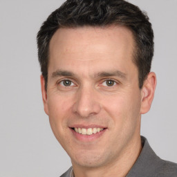 Joyful white adult male with short  brown hair and brown eyes