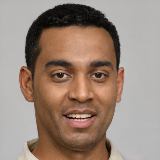 Joyful black young-adult male with short  black hair and brown eyes