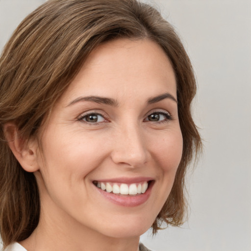 Joyful white young-adult female with medium  brown hair and green eyes