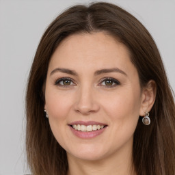 Joyful white young-adult female with long  brown hair and brown eyes