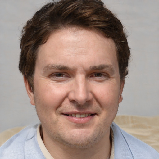 Joyful white adult male with short  brown hair and blue eyes