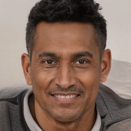Joyful latino adult male with short  brown hair and brown eyes