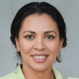 Joyful latino young-adult female with medium  brown hair and brown eyes