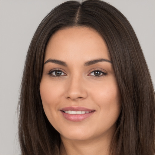 Joyful white young-adult female with long  brown hair and brown eyes