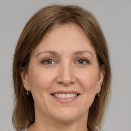 Joyful white adult female with medium  brown hair and grey eyes