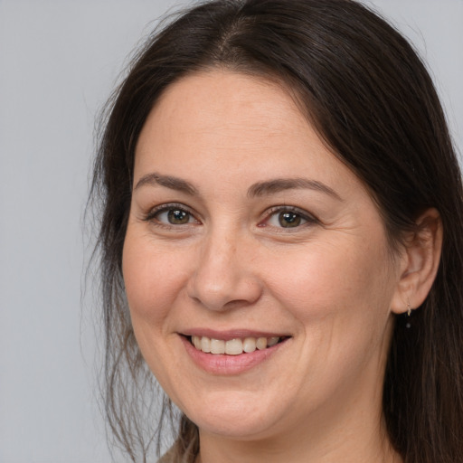 Joyful white adult female with long  brown hair and brown eyes