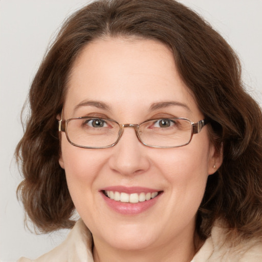 Joyful white adult female with medium  brown hair and green eyes