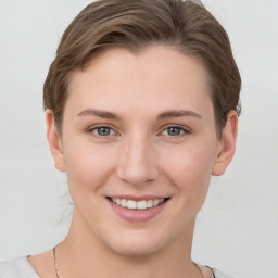 Joyful white young-adult female with short  brown hair and grey eyes