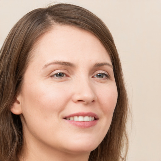 Joyful white young-adult female with long  brown hair and grey eyes