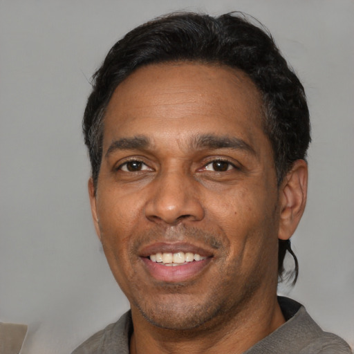 Joyful black adult male with short  black hair and brown eyes