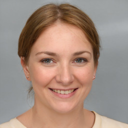 Joyful white young-adult female with medium  brown hair and grey eyes