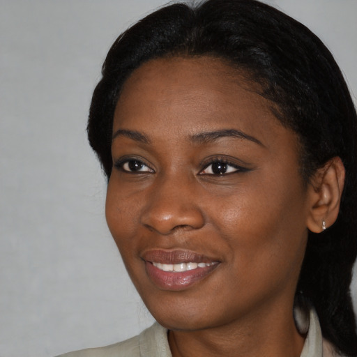 Joyful black young-adult female with long  black hair and brown eyes