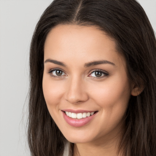 Joyful white young-adult female with long  brown hair and brown eyes