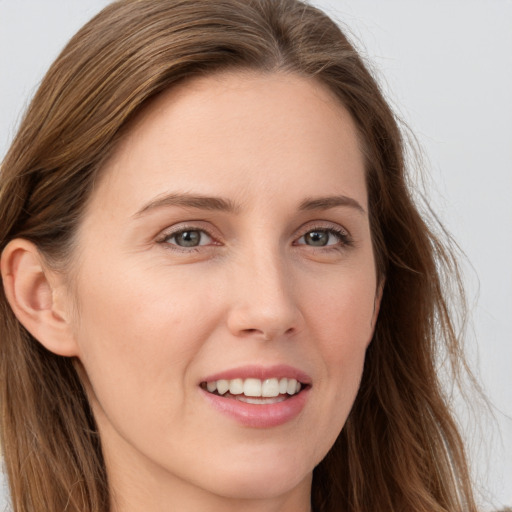 Joyful white young-adult female with long  brown hair and grey eyes