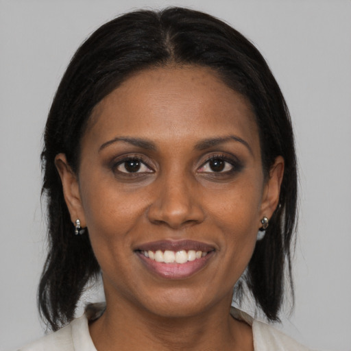 Joyful black young-adult female with medium  brown hair and brown eyes