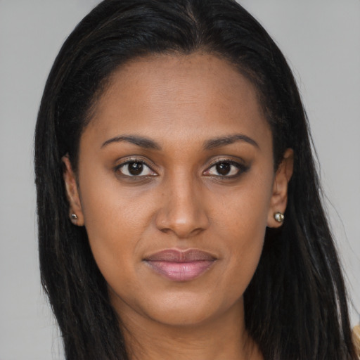 Joyful black young-adult female with long  brown hair and brown eyes